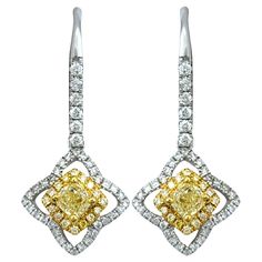 This stunning pair of Canary Star yellow and white diamond dangle earrings are exquisitely set in 18 karat yellow and white gold. These captivating earrings feature a dazzling array of diamonds, artfully arranged to create a radiant display of sparkle and color. The blend of yellow and white gold enhances the brilliance of the coordinating colored diamonds, while the elegant dangle design adds movement and sophistication. Perfect for special occasions or adding a touch of luxury to any outfit, these earrings combine exceptional craftsmanship with timeless beauty, making them a cherished addition to any fine jewelry collection. This piece is in very good estate condition and has been professionally cleaned and polished. It comes with an appraisal card, verifying its authenticity and current