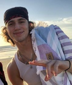 a man pointing at the camera while wearing a bandana and holding his finger up in front of him