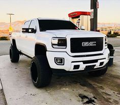 a white truck parked in front of a gas station