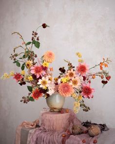 a vase filled with lots of flowers on top of a table