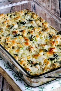 a casserole dish with broccoli and cheese in it on a wooden table