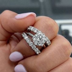 a woman's hand holding two engagement rings