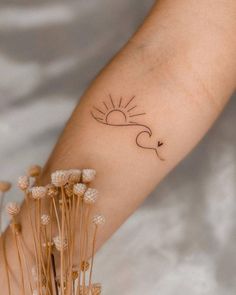 a woman's arm with a small tattoo on it