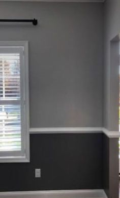 an empty room with gray walls and white trim on the window sill, painted in dark grey