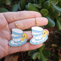 a pair of blue and white tea cup earrings