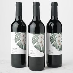 three bottles of wine sitting next to each other on a white counter top with the label in front of them