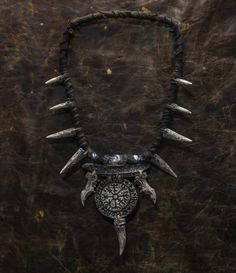 Embrace your edgy side with our unique neck jewelry. Handcrafted to elevate any shaman costume, LARP outfit, or fantasy ensemble, this piece is a fusion of craft and imagination. Perfect for post-apocalyptic or Halloween settings, its intricate design features bones, fangs, and a striking round ornament. Whether you're a horror lover seeking a standout gift or adding a touch of mystique to your festival attire, this leather necklace is a versatile accessory that demands attention. Necklace with ornament and bones. Suitable for fantasy and post-apocalypse. All bone elements and decor are made of hard plastic and painted by hand. It is possible to manufacture the quantity according to your order. ❗️DETALIS❗️ Our products are meticulously crafted by skilled artisans, ensuring uniqueness and q Shaman Costume, Larp Outfit, Barbarian Costume, Festival Attire, Inner Warrior, Neck Jewelry, Horror Lovers, Bone Necklace, Bone Jewelry