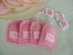 some cookies are sitting on a plate next to pink felt