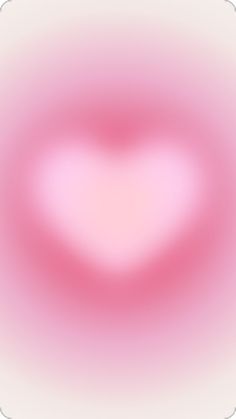 a blurry image of a pink heart in the middle of it's frame