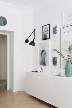 a room with white walls and pictures on the wall