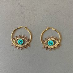 Evileye protection hoop earrings beads hoop earrings Miyuki earrings Miyuki bead earrings evil eye shape earrings bohemian earrings everyday Add a unique style to any look with these bohemian style earrings featuring an evil eye. Constructed with Miyuki seed beads in a combination of aqua and gold seed beads, they are sure to catch any eye with their stunning design. Lightweight and comfortable. Item Details *Material: Stainless Steel *Stone: Glass seed beads *Earring size: 1.57in (4cm) *Weight: