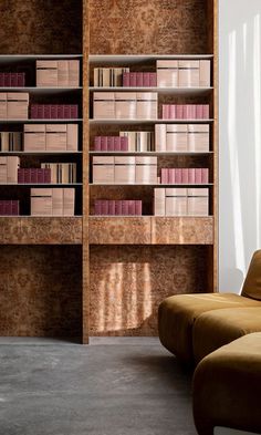 a living room filled with furniture and bookshelves next to a wall mounted book case