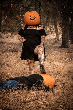 a woman in black dress sitting on top of an orange pumpkin