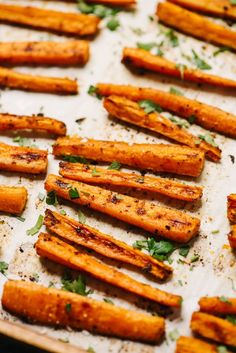 baked sweet potato sticks with parsley on a baking sheet, ready to be eaten