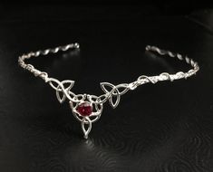 I will fabricate this Celtic Knot inspired wedding circlet, or diadem, in sterling silver with an 8mm gorgeous and stunningly merlot colored faceted Garnet gemstone, which I set in a sturdy 4 prong sterling silver setting. This is perfect for an Irish wedding, a Renaissance themed one! This piece has a Celtic vibe, yet still elegant to blend nicely with a classic style gown, too. Perfect for those celebrating their Celtic, Irish or alternative spirit, yet elegant and classy for any bride-to-be! Silver Teardrop Crown Jewelry For Anniversary, Handmade Teardrop Crown Jewelry For Wedding, Traditional Hand Forged Wedding Jewelry, Traditional Hand Forged Jewelry For Wedding, Silver Round Crown Jewelry For Anniversary, Wedding Circlet, Bridal Circlet, Celtic Knot Wedding, Garnet Wedding