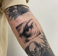 a person with a tattoo on their arm has an eyeball in the shape of a demon