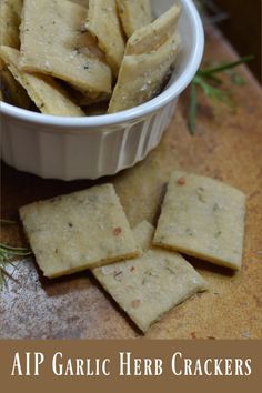 garlic herb crackers in a white bowl on a wooden table with rosemary sprigs