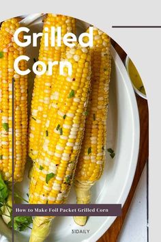 grilled corn on a white plate with herbs