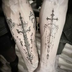 two people with cross tattoos on their legs