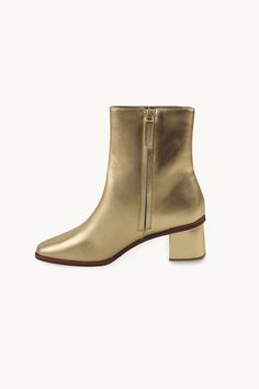 These ankle boots are crafted from high-quality leather in a metallic gold hue. They feature a side zipper closure, a low heel, and a sleek design. Designed for a bold and stylish look. Use our virtual size assistant to find your perfect fit. Gold Ankle Boots For Fall, Gold Leather Ankle Heeled Boots, Gold Ankle Leather Heeled Boots, Chic Gold Heeled Boots For Fall, Chic Gold Boots With Sculpted Heel, Gold Leather Chic Heeled Boots, Chic Gold Leather Heeled Boots, Chic Metallic Heeled Boots For Fall, Chic Gold Leather Boots