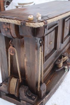 an old wooden chest with rope and seas on it's sides in the snow