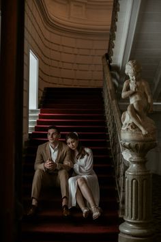 a man and woman are sitting on the stairs