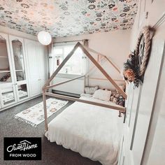 a room with a bed, rugs and wallpaper on the ceiling is shown