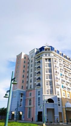 a tall building sitting next to a lush green field