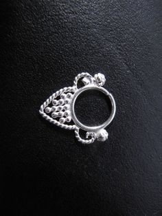 a silver ring on a black surface