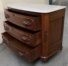 an old dresser with marble top and drawers