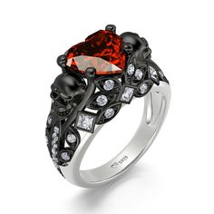 a black and white ring with an orange heart shaped stone in the center, surrounded by diamonds