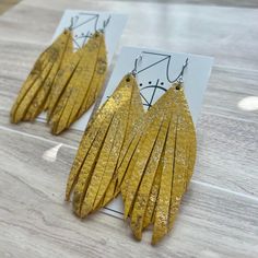 Genuine sparkle yellow toned metallic dazzle leather cut into two elongated fringe layers on nickel free hardware. This listing is for one pair of earrings. Photos depicting multiple pairs are for styling purposes only. The last photo shown is of another Alexis style earring for measurement purposes. Yellow Fringe Jewelry For Party, Adjustable Gold Tassel Earrings With Fringe, Elegant Yellow Fringe Earrings, Leather Cuts, Yellow Tones, Fringe Earrings, Leather Jewelry, Jewelry Earrings Dangle, Jewelry Earrings