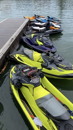 there are many boats that are docked at the water's edge and one is yellow