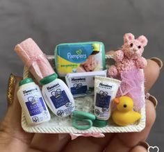 a person holding a small tray with baby items in it