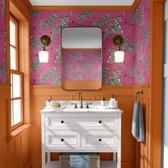 a bathroom with pink and orange wallpaper, two sinks and a mirror on the wall