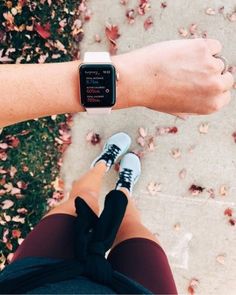 a person wearing an apple watch on their wrist with autumn leaves around them and the time displayed