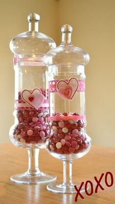 two wine glasses filled with candy on top of a table