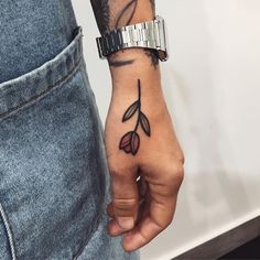 a person with a tattoo on their arm holding onto a wristband and wearing a watch