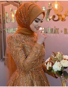 a woman in a hijab holding a bouquet of flowers