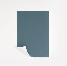 a blue piece of paper with a corner cut out on the side, against a white wall