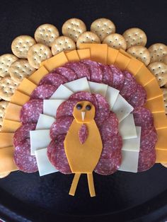 a turkey shaped meat and cheese platter with crackers in the shape of cookies