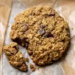 an oatmeal cookie is sitting on wax paper