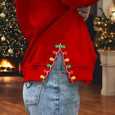 a person wearing a red sweater with christmas lights on it