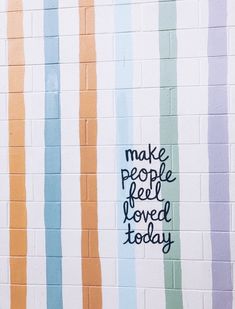 a wall painted with colorful stripes that says make people feel loved today