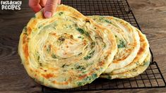 there is a stack of flat breads on the cooling rack, and it looks like spinach