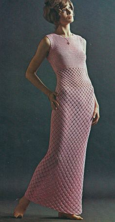 a woman in a pink crocheted dress poses for a photo with her hands on her hips