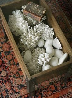 a wooden box filled with white flowers on top of a rug