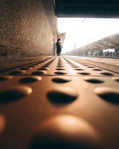 a person standing in front of a wall with lots of circles on it's surface