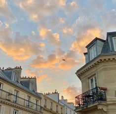 the sky is pink and blue as the sun sets over some buildings in paris, france