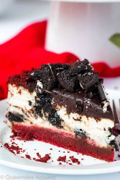 a piece of cake on a white plate with a fork and red napkin in the background